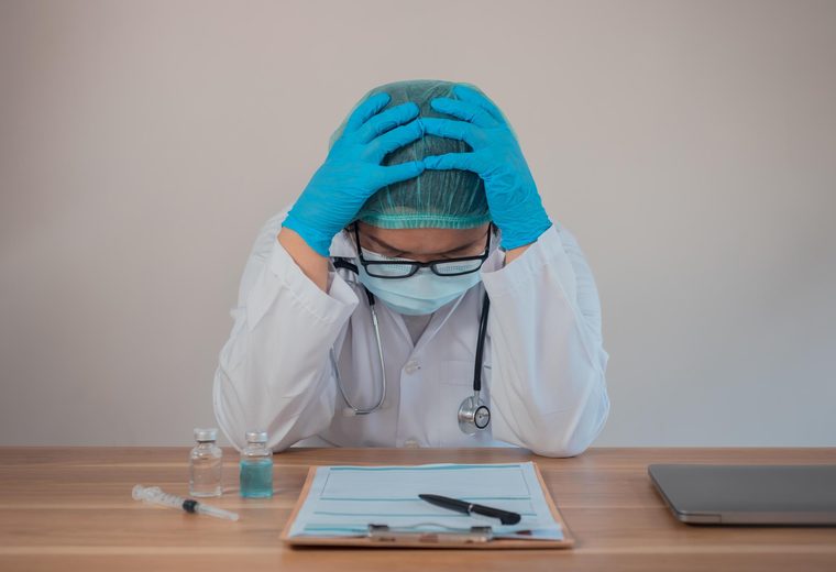 Physician at a desk reviewing a patient chart